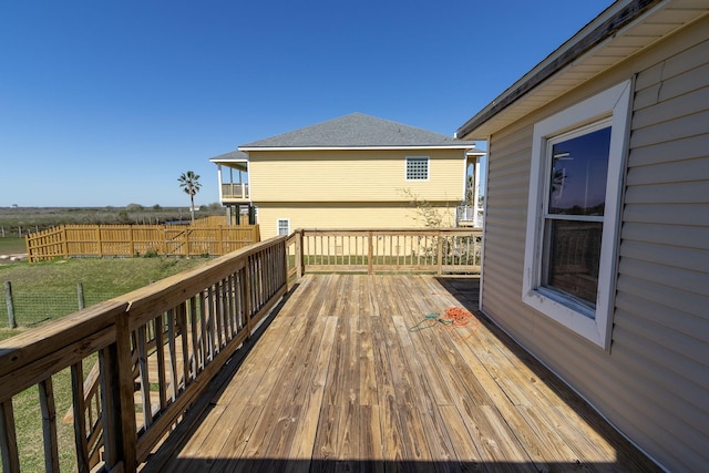 2027 103rd St, Galveston, TX 77554 - wooden deck featuring fence and a lawn