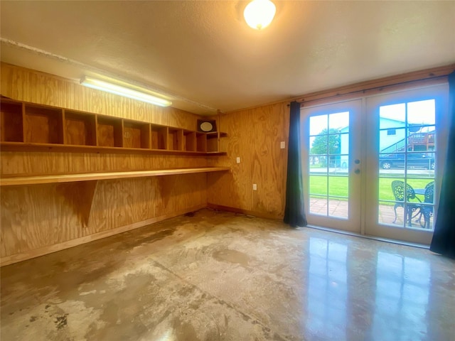 2027 103rd St, Galveston, TX 77554 - below grade area with wood walls, baseboards, and french doors
