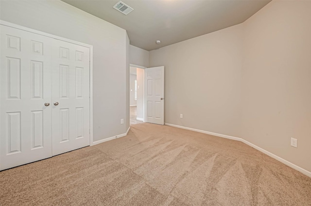 unfurnished bedroom featuring a closet, baseboards, visible vents, and carpet floors