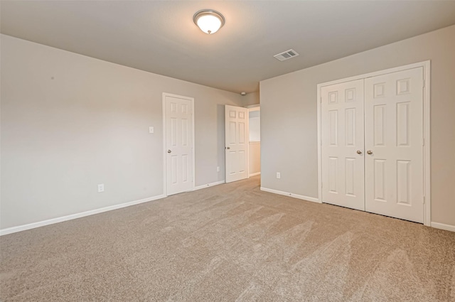 unfurnished bedroom featuring visible vents, baseboards, a closet, and carpet