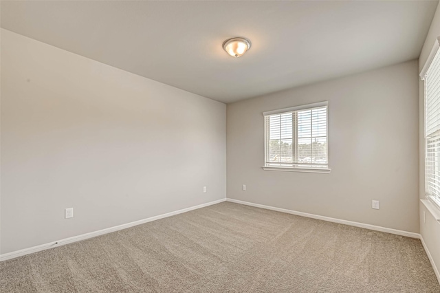 carpeted empty room with baseboards