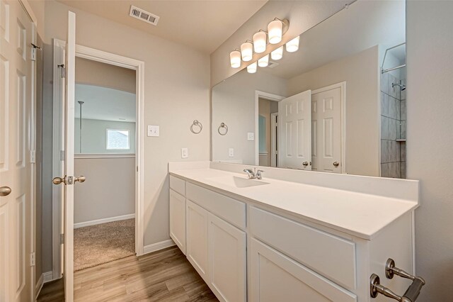 full bathroom with visible vents, baseboards, vanity, and wood finished floors