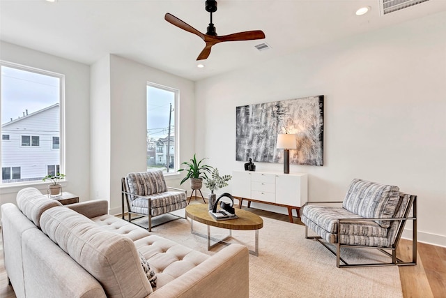 living room featuring wood finished floors, a ceiling fan, visible vents, and recessed lighting