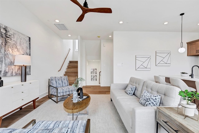 living room featuring wood finished floors, recessed lighting, visible vents, and stairway