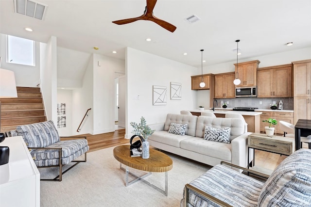 living area with light wood-style floors, recessed lighting, and visible vents