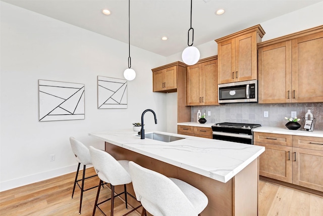 kitchen featuring stainless steel microwave, a sink, range with electric cooktop, light wood finished floors, and backsplash
