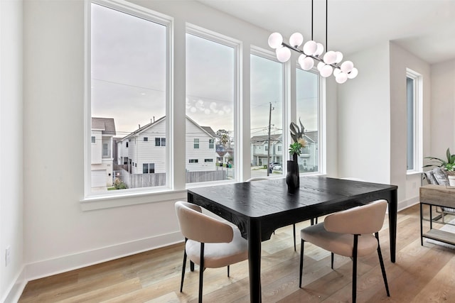 dining space featuring light wood-style flooring, a wealth of natural light, and baseboards