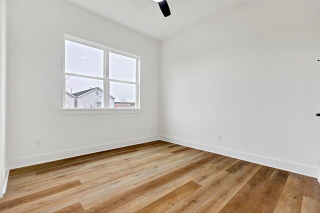 spare room with light wood-style flooring, ceiling fan, and baseboards