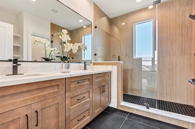 bathroom featuring a stall shower, a healthy amount of sunlight, and a sink