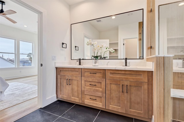 full bathroom with ceiling fan, visible vents, a sink, double vanity, and baseboards