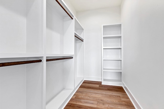 walk in closet with wood finished floors
