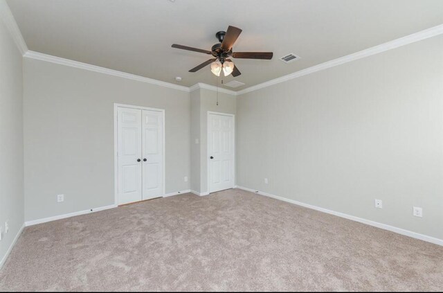 interior space with visible vents, baseboards, ornamental molding, and carpet floors