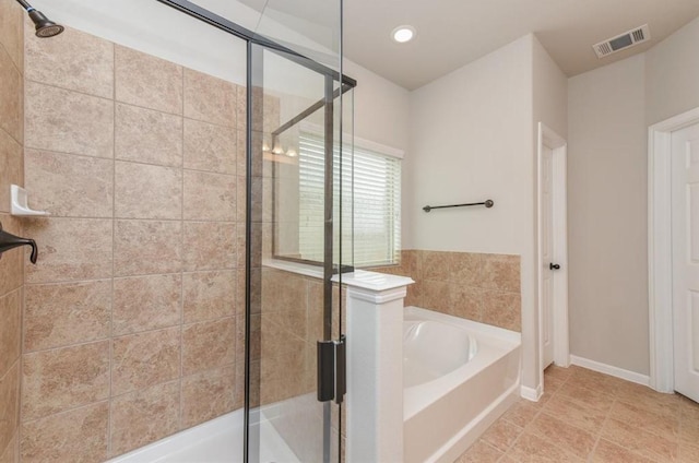bathroom with visible vents, baseboards, a garden tub, and a stall shower