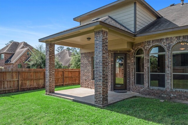 1715 Laremont Bend Dr, Spring, TX 77386 - view of exterior entry featuring brick siding, a patio area, and roof with shingles