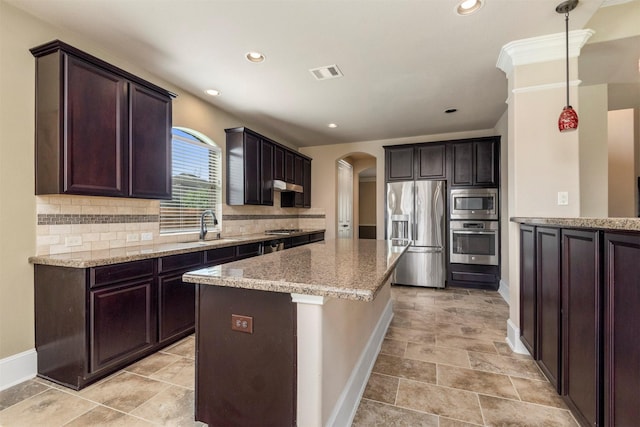 1715 Laremont Bend Dr, Spring, TX 77386 - kitchen with appliances with stainless steel finishes, arched walkways, a sink, baseboards, and recessed lighting