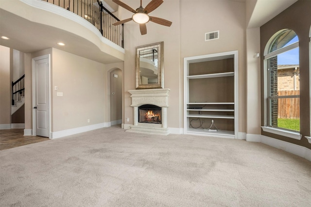 1715 Laremont Bend Dr, Spring, TX 77386 - unfurnished living room featuring built in features, carpet, a ceiling fan, healthy amount of natural light, and a high ceiling
