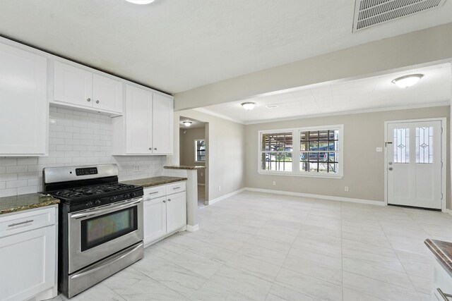 kitchen with baseboards, ornamental molding, backsplash, visible vents, and stainless steel gas stove