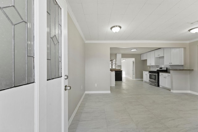 kitchen featuring stainless steel gas stove, baseboards, and ornamental molding