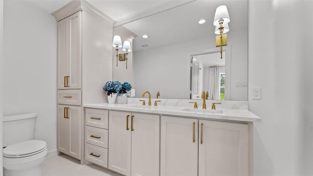 bathroom with a sink, toilet, double vanity, and recessed lighting