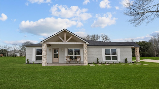 back of property with brick siding and a lawn