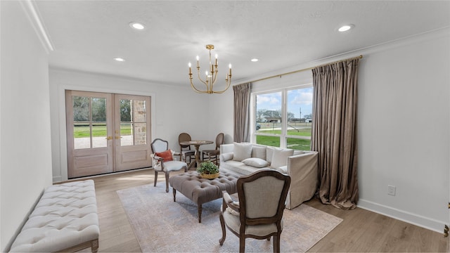living area featuring light wood-style floors, french doors, a notable chandelier, and recessed lighting