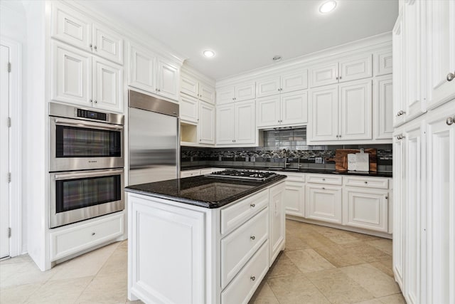 2209 Devonshire St Unit B, Houston, TX 77019 - kitchen with appliances with stainless steel finishes, white cabinetry, backsplash, a kitchen island, and recessed lighting