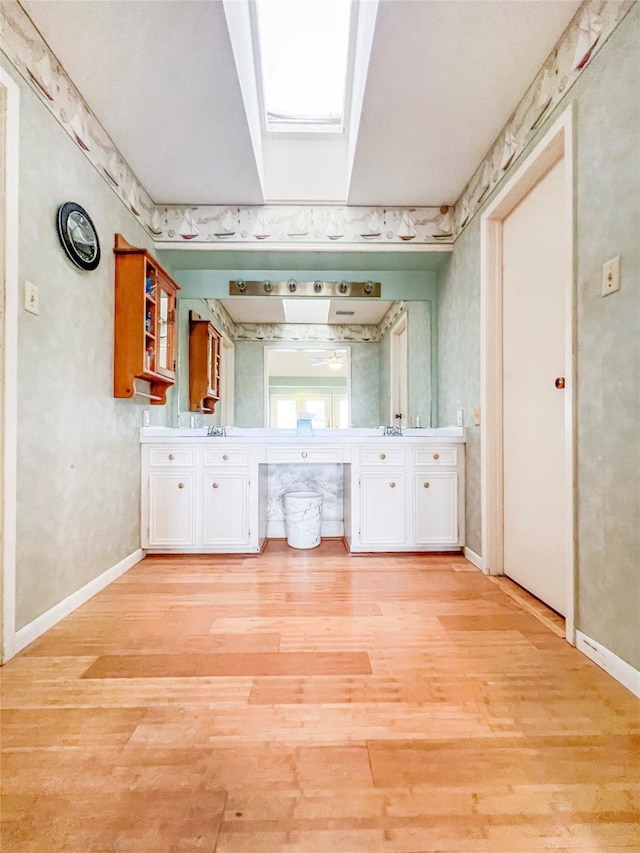3203 Bayou Dr, La Porte, TX 77571 - bathroom featuring wood finished floors, double vanity, and baseboards
