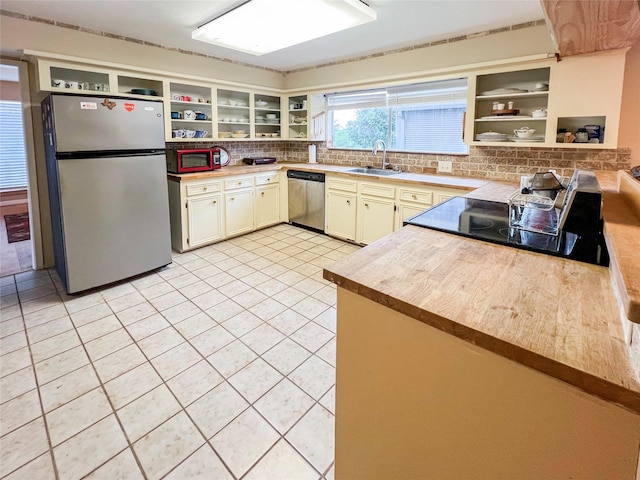 3203 Bayou Dr, La Porte, TX 77571 - kitchen with appliances with stainless steel finishes, open shelves, a sink, tasteful backsplash, and light tile patterned floors