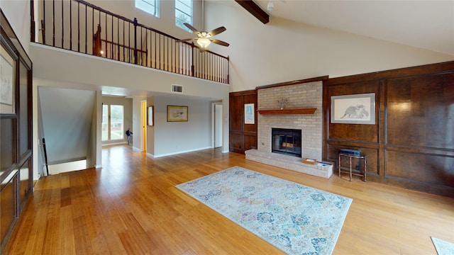 3203 Bayou Dr, La Porte, TX 77571 - living room with high vaulted ceiling, ceiling fan, a brick fireplace, wood finished floors, and beamed ceiling