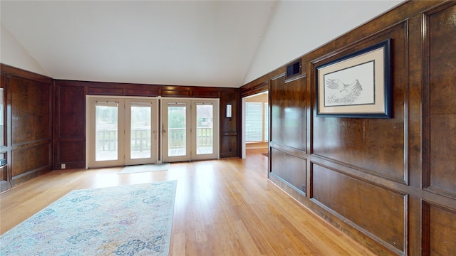 3203 Bayou Dr, La Porte, TX 77571 - unfurnished room featuring lofted ceiling, light wood-style floors, a decorative wall, and wood walls