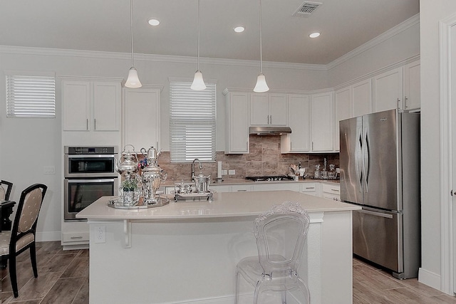 247 Arabian Dr, The Woodlands, TX 77382 - kitchen with visible vents, under cabinet range hood, white cabinets, and appliances with stainless steel finishes
