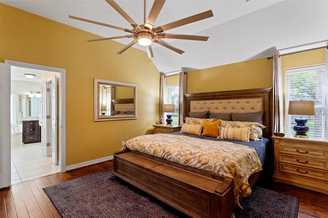 bedroom featuring baseboards, multiple windows, hardwood / wood-style floors, and lofted ceiling