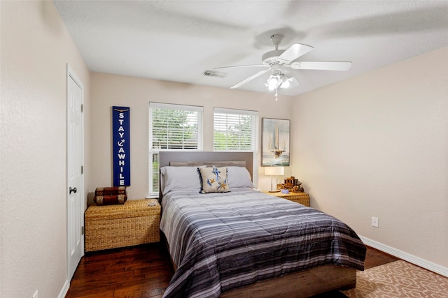 bedroom featuring ceiling fan, baseboards, visible vents, and wood finished floors