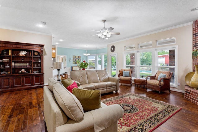 living room featuring dark wood finished floors, ornamental molding, and ceiling fan with notable chandelier