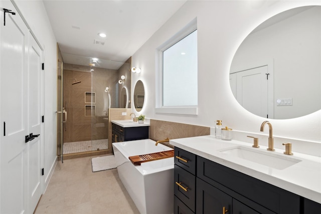 4323 Rogers St, Houston, TX 77022 - bathroom with two vanities, a shower stall, a freestanding tub, visible vents, and a sink