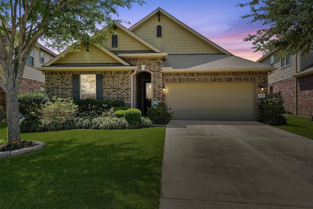 view of front of home with driveway, an attached garage, a front lawn, brick siding, and a shingled roof