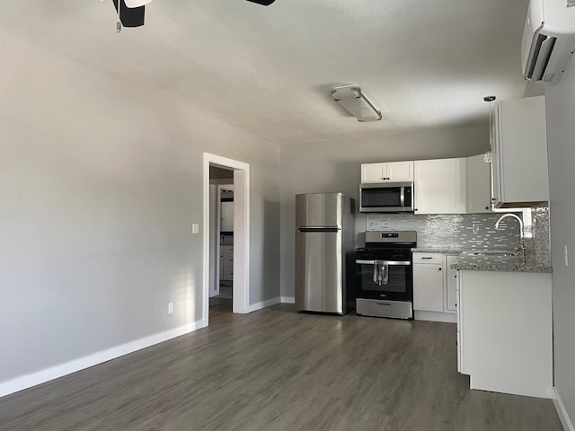 1701 40th St, Galveston, TX 77550 - kitchen with appliances with stainless steel finishes, a sink, a ceiling fan, dark wood-type flooring, and baseboards