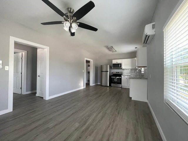 1701 40th St, Galveston, TX 77550 - unfurnished living room with a wall mounted air conditioner, ceiling fan, baseboards, and dark wood-style flooring
