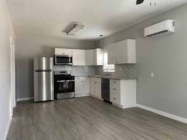 1701 40th St, Galveston, TX 77550 - kitchen featuring stainless steel appliances, a wall mounted air conditioner, dark wood finished floors, decorative backsplash, and baseboards