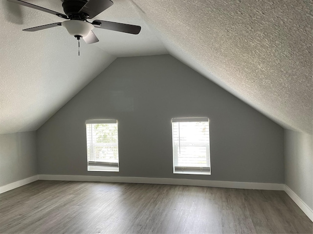 1701 40th St, Galveston, TX 77550 - bonus room featuring wood finished floors, a textured ceiling, lofted ceiling, and baseboards