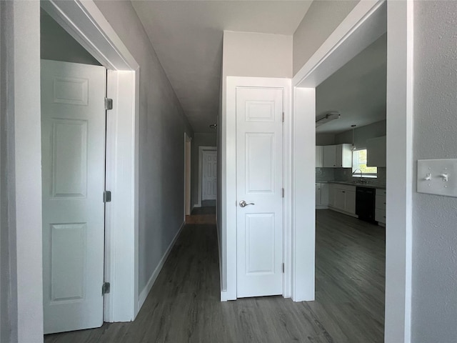 1701 40th St, Galveston, TX 77550 - corridor featuring a sink, dark wood-style floors, and baseboards