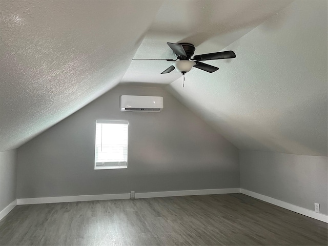 1701 40th St, Galveston, TX 77550 - bonus room featuring a wall unit AC, a textured ceiling, wood finished floors, a ceiling fan, and baseboards
