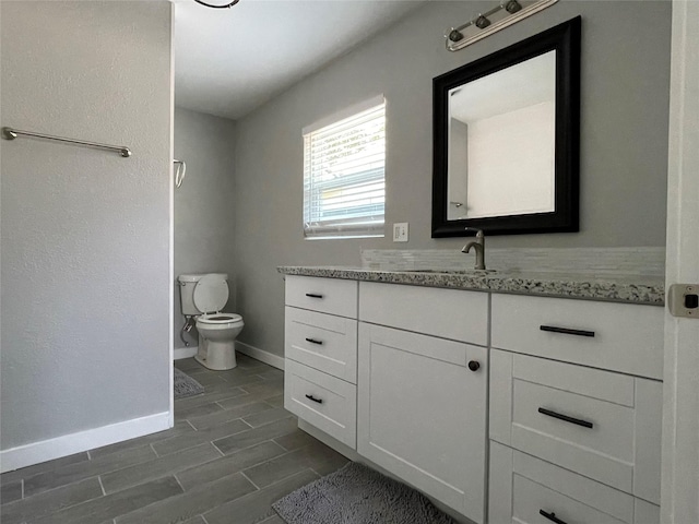1701 40th St, Galveston, TX 77550 - bathroom featuring vanity, toilet, baseboards, and wood tiled floors