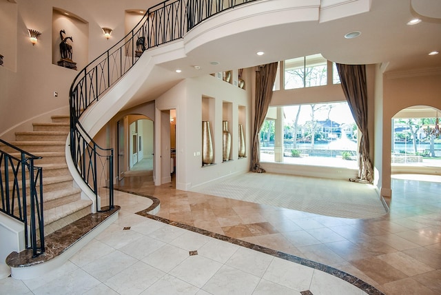 2 Royal Hampton Ct, Sugar Land, TX 77479 - entrance foyer featuring arched walkways, a wealth of natural light, a towering ceiling, and stairs