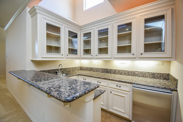 2 Royal Hampton Ct, Sugar Land, TX 77479 - kitchen featuring a peninsula, glass insert cabinets, dark stone counters, and a sink
