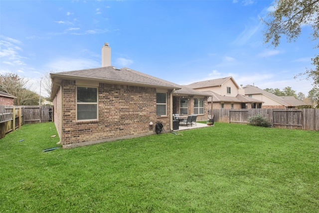back of property with a patio, brick siding, a fenced backyard, and a lawn