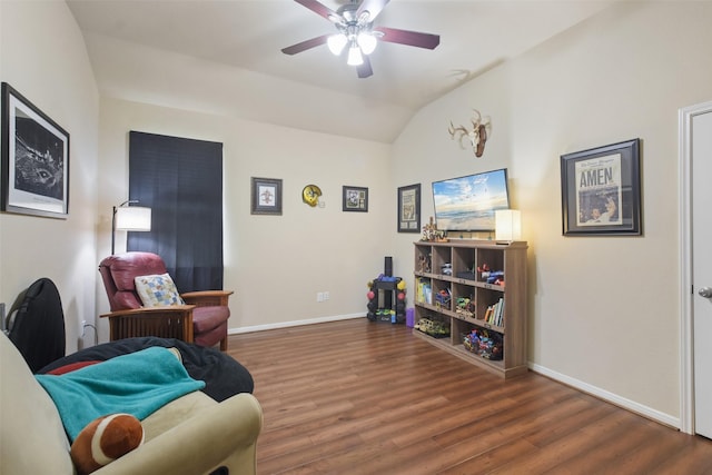 living area featuring baseboards, vaulted ceiling, a ceiling fan, and wood finished floors