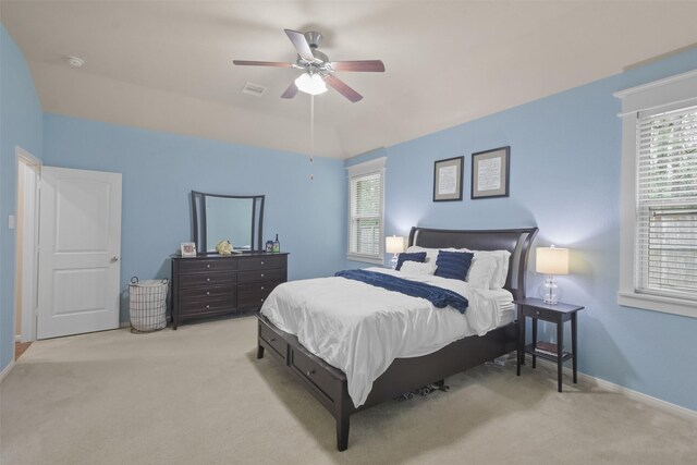 carpeted bedroom featuring visible vents, baseboards, and a ceiling fan