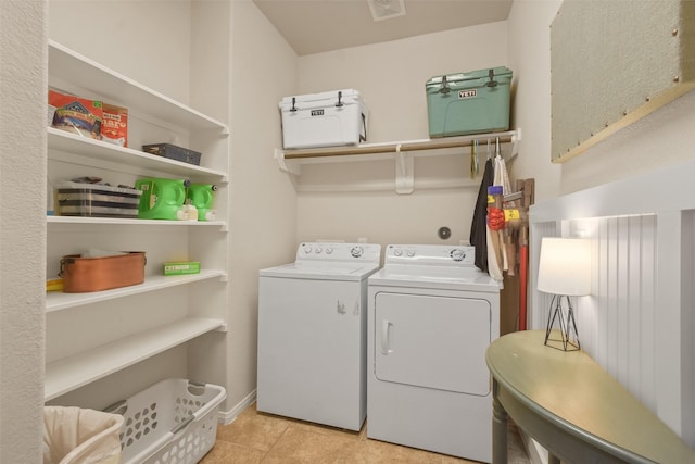 clothes washing area with washer and dryer, laundry area, and light tile patterned flooring