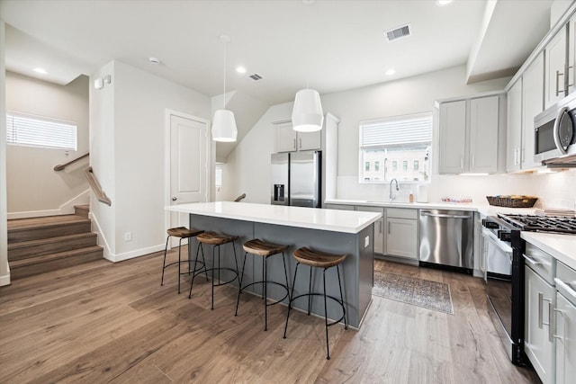 kitchen featuring appliances with stainless steel finishes, a breakfast bar area, visible vents, and plenty of natural light